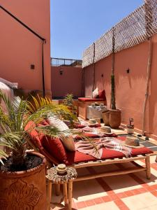 - un lit sur une terrasse avec des plantes en pot dans l'établissement Riad Jardin de Malia, à Marrakech