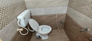 a bathroom with a white toilet in a stall at SP resort inn in Yercaud