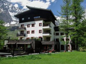 a large building with a mountain in the background at Ski, stay, and savour Aosta Valley in Breuil-Cervinia