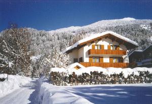 a house covered in snow in front of a mountain at Haus Tschofen in Schruns