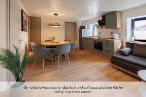 a living room and kitchen with a table and a couch at CASA BENJI - Familienfreundliche FeWo - Landhausstil - Garten - Parkplatz in Pirna