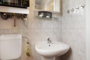 a bathroom with a white sink and a toilet at Haffmöwe Ferienhaus 96 in Mönkebude +16 photos