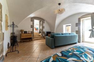 a living room with a blue couch in a room at Gîte La Clé de Voûte in Aydat