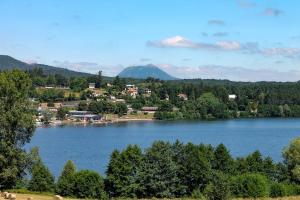 a view of a lake with a town and trees at Gîte La Clé de Voûte in Aydat +5 photos