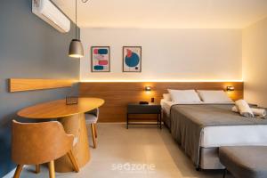 a hotel room with a bed and a table at OGD - Condominio com Piscina e Churrasqueira em Floripa in Florianópolis +33 photos