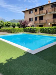 a large blue swimming pool in front of a building at Maison della Presolana in Songavazzo