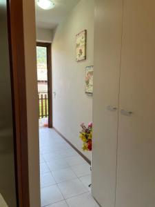 a hallway with a door leading into a room with flowers at Maison della Presolana in Songavazzo