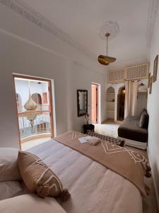 une chambre avec un grand lit et une grande fenêtre dans l'établissement Riad Jardin de Malia, à Marrakech
