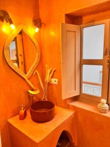 une salle de bain avec un lavabo et un miroir dans l'établissement Riad Jardin de Malia, à Marrakech