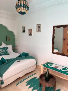 une chambre avec un lit, un miroir et une table dans l'établissement Riad Jardin de Malia, à Marrakech