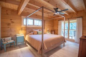 a bedroom with a bed and a ceiling fan at Riverstead Cabin- Riverfront, Wrap Around Porch, Hot Tub & More in Warrensville