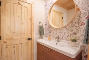 a bathroom with a sink and a mirror at Riverstead Cabin- Riverfront, Wrap Around Porch, Hot Tub & More in Warrensville +39 photos