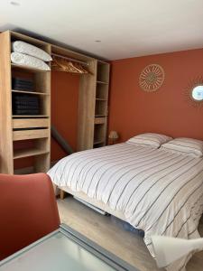 a bedroom with a large bed and a chair at appartement 4 personnes yvetot maurienne express in Saint-Jean-de-Maurienne