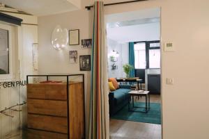 a living room with a blue couch and a table at Hotel Litteraire Marcel Ayme, BW Premier Collection in Paris