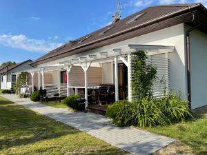 a house with a porch with a patio at Domki Letniskowe Ratownik in Sarbinowo