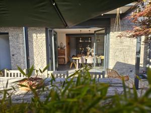 a house with a patio with a table and chairs at Hey Spreewald Ferienapartments in Lübben