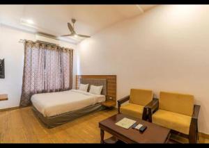 a bedroom with a bed and a table and a chair at Hotel Global Inn Glod in Lucknow +16 photos