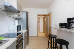 a kitchen with two bar stools in a room at FLEX Aparts - möblierte 2-Raum Wohnung in Zwickau in Zwickau +22 photos