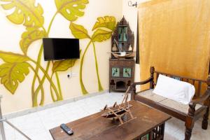 a living room with a couch and a tv on a wall at MALINDi LUXURY HOTEL in Malindi