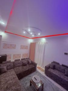 a living room with couches and a red line on the ceiling at Bon séjour in Bouaké