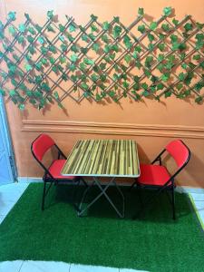 a table and two chairs sitting next to a wall at Bon séjour in Bouaké