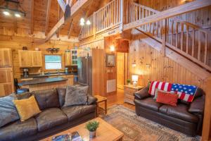 a living room with a couch and a kitchen at Updated Cabin Mins from Downtown West Jefferson- Hot Tub, Porches, Dogs OK in West Jefferson