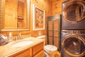 a bathroom with a sink and a washing machine at Updated Cabin Mins from Downtown West Jefferson- Hot Tub, Porches, Dogs OK in West Jefferson +10 photos