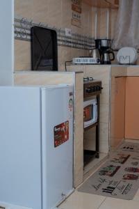 a small kitchen with a refrigerator and an oven at Couple-Friendly Studio Apartment In Pangani in Nairobi