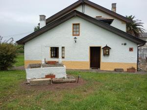 a white house with a door and a yard at Casa De la Agüera in Busto