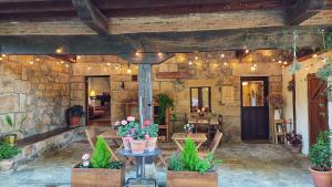a stone building with a table with flowers on it at Posada La Dalia in Castillo-Pedroso