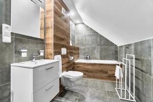 a bathroom with a toilet and a sink and a tub at Apartmány s výhledem na Plešivec by Mountain ways in Abertamy