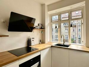 a kitchen with a sink and a counter top at Spacious Nordic Design Vesterbro Home I 3 min to Metro in Copenhagen