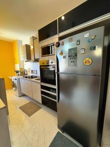 a kitchen with a stainless steel refrigerator with magnets at Apartamento moderno 15 min da COP30 Wi Fi vaga checkin flexivel COP30 Belém PA Hangar Centro de Convenções in Belém