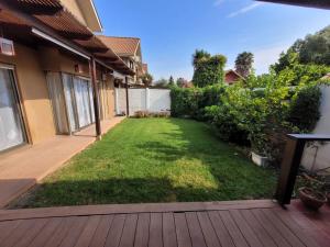 a yard with a deck and a lawn withgrass at Linda casa condominio in Santiago