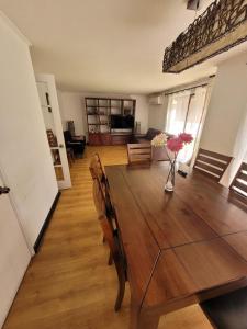 a dining room with a wooden table with flowers in a vase at Linda casa condominio in Santiago
