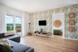 a living room with a couch and a tv on a wall at Casa da Vinha in Óbidos