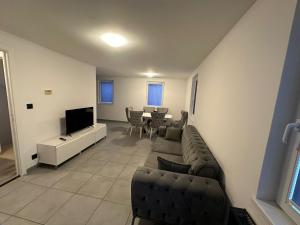 a living room with a couch and a television at Marmus in Pfaffenhoffen