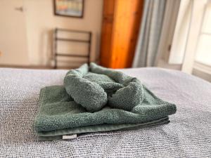 a green towel sitting on top of a bed at Stunning Jurassic 3 bed with views over Lyme Bay in Lyme Regis +30 photos