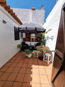 a patio with a table and an umbrella at Casa Avó Bia in Reguengos de Monsaraz