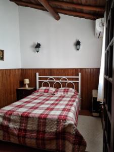 a bedroom with a bed with a plaid blanket at Casa Avó Bia in Reguengos de Monsaraz