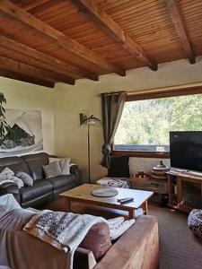 レ・コンタミンヌ・モンジョワにあるラ ジェリノットゥのソファとテーブルのあるリビングルーム