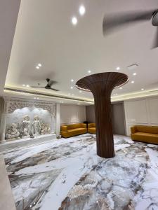 a lobby with a marble floor and a pillar at Bawa Hotel in Jāmb