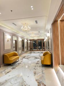 a lobby with two yellow chairs and a marble floor at Bawa Hotel in Jāmb