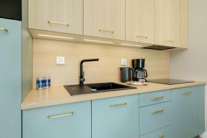 eine Küche mit Spüle und Arbeitsplatte in der Unterkunft Polanki Aqua Stylowy Apartament 300 m od Plaży by Noclegi Renters in Radzikowo