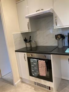 a kitchen with a stove with a black counter top at Wookey Holiday Flat in Wookey +3 photos