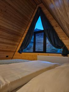 (( Gergeti ))Gergeti Twins - Cottages的木屋内设有一间带大窗户的卧室