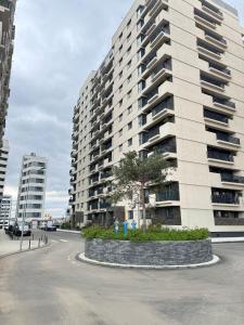 a large apartment building with a tree in front of it at Iassy Airport Luxury Apartments with Parking in Iaşi