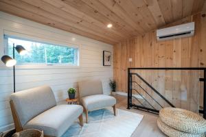 Una sala de estar con dos sillas y una ventana. en Spa et River - Le Grand-Pic, en Saint-Alexis-des-Monts