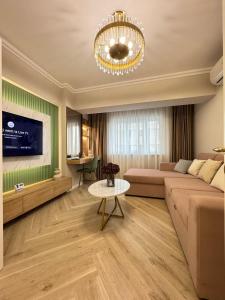 a living room with a couch and a chandelier at Iassy Airport Luxury Apartments with Parking in Iaşi