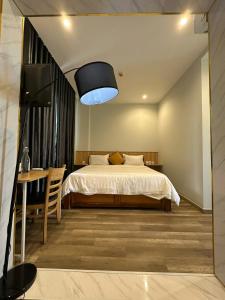 a bedroom with a bed and a table with a desk at 118 Orchid in Phú Quốc